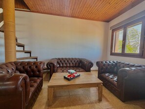 Una sala de estar con un sofá modular, una mesa de centro y un techo de madera.