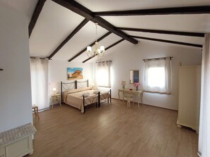 Un dormitorio con cama, mesitas de noche, un escritorio, una silla, un espejo y un cuadro en la pared.