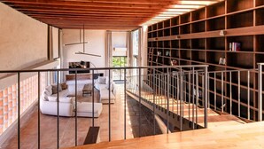 Ein modernes Interieur mit Treppe, einer Sofagarnitur und einem Bücherregal.