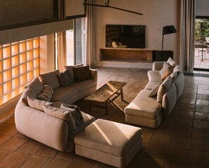Un salon moderne avec un canapé d’angle, une table basse et une cheminée.