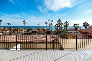 A coastal residential area with tiled roofs, palm trees, and a clear blue sky. - Casa Postal (Puerto Peñasco)