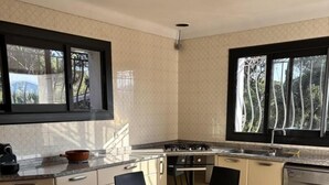 A modern kitchen with a dining table, chairs, a stove, and a dishwasher. - Vacation Rental 8-minute walk from the ocean - top floor of a villa (ROQUEBRUNE SUR ARGENS)