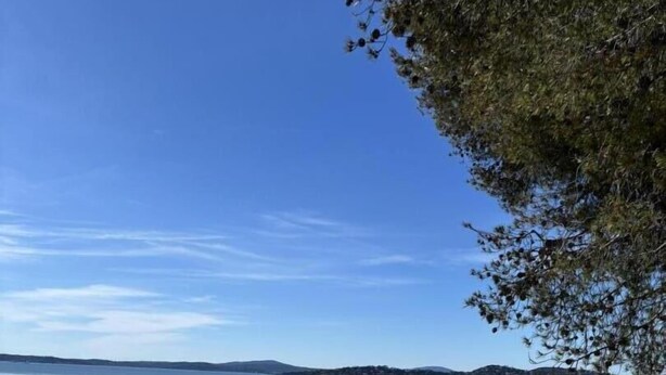 A beach with clear water, a sandy shore, and distant hills. - Vacation Rental 8-minute walk from the ocean - top floor of a villa (ROQUEBRUNE SUR ARGENS)