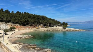 Un paysage côtier caractérisé par une eau bleue et limpide, un terrain rocheux et une végétation luxuriante.