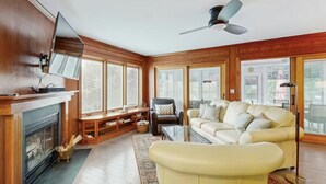 A living room with a fireplace, a sofa, a television, and a ceiling fan. - 2 Story Townhome-Walk to Downtown Lewes! (Lewes)