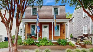 A two-story house with a front porch, a mailbox, and two flags. - 2 Story Townhome-Walk to Downtown Lewes! (Lewes)