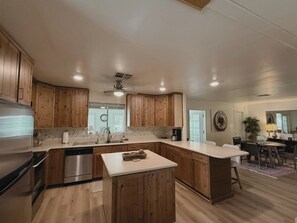 Eine moderne Küche mit Holzausbau, Edelstahlgeräten und einer zentralen Kochinsel.