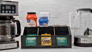 Eine Küchenzeile mit Kaffeemaschine, Mixer und Kaffeemühle auf der Arbeitsfläche.