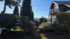 A house with a balcony, surrounded by trees and a clear sky. - Vancouver View Home w/ Hot Tub Near Downtown (Vancouver)