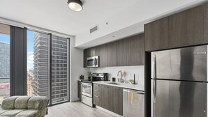 Eine moderne Küche mit einem Edelstahl-Kühlschrank, einer Mikrowelle und einem eingebauten Backofen.