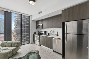 A modern kitchen with a stainless steel refrigerator, a microwave, and a built-in oven. - Luxury High-Rise Bay Views + Pool + Parking Steps to Bayside & Brickell (Miami)