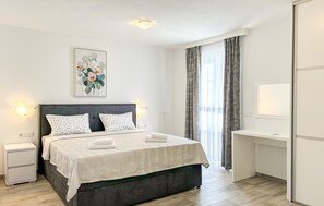 A modern bedroom with a bed, bedside tables, a painting, and a desk. - Gorgeous home in Stancija Vergotini (Stancija Vergotini)