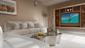 A modern living room with a sectional sofa, a coffee table with decorative items, a flat-screen TV, and a wooden shelving unit with decorative objects. - Luxurious home in Vabriga (Vabriga)