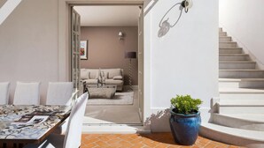 A modern interior with a sofa, a coffee table, a potted plant, and a staircase. - Luxurious home in Vabriga (Vabriga)
