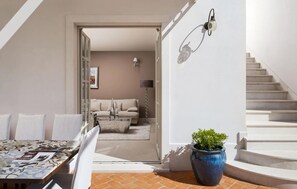 Ein modernes Interieur mit einer Couch, einem Couchtisch, einer Topfpflanze und einer Treppe.