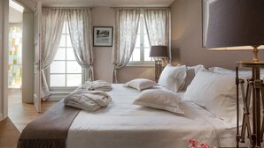 A neatly made bed with pillows and a blanket, a bedside lamp, and a framed picture on the wall. - Luxurious home in Vabriga (Vabriga)