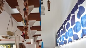 A staircase with wooden steps, a blue accent wall, and hanging kitchen utensils. - Seu Lar na Praia Grande (Arraial do Cabo)
