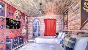 Ein Zimmer mit einer Steinsäule, einem Bett mit weißer Bettwäsche, einem roten Vorhang und einer Chandeliebre.