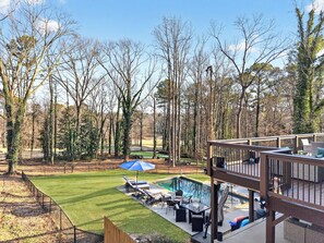 A backyard with a swimming pool, lounge chairs, and a deck. - World Cup Luxury • Pool/Hot Tub •Walkable • On Golf Course • Prime  Atl location (Atlanta)