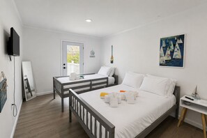 Habitació d'hotel amb un llit, escriptori, cadira, televisió i un quadre a la paret.