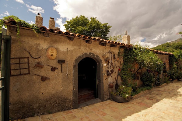 An old building with a stone facade, a tiled roof, and an arched entrance.