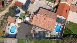 An aerial view of a residential property with a swimming pool, solar panels, and a fenced garden area. - Awesome home in Jursici (Jursici)