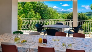 Une table dressée à l’extérieur, offrant une vue sur un paysage luxuriant.