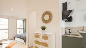 Eine moderne Wohnung mit einer Küchenzeile, einem großen Spiegel und Blick ins Freie.