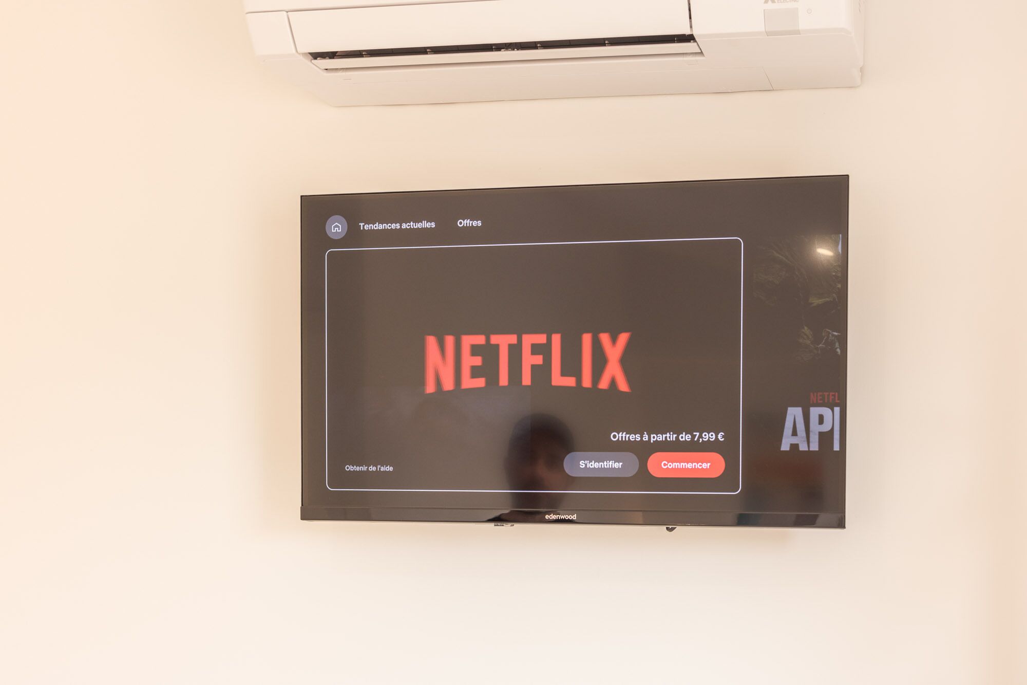 Ein Flachbildfernseher an der Wand, der das Netflix-Logo und die Benutzeroberfläche zeigt.