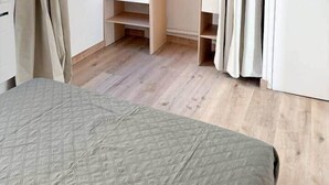 Une chambre à coucher avec un lit, une armoire et une porte.