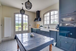 Eine Küche mit großem Fenster, Spüle, Herd und Deckenventilator.
