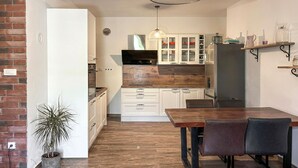 Eine moderne Küche mit Holzarbeitsplatten, weißen Schränken und einem Essbereich mit Tisch und Stühlen.
