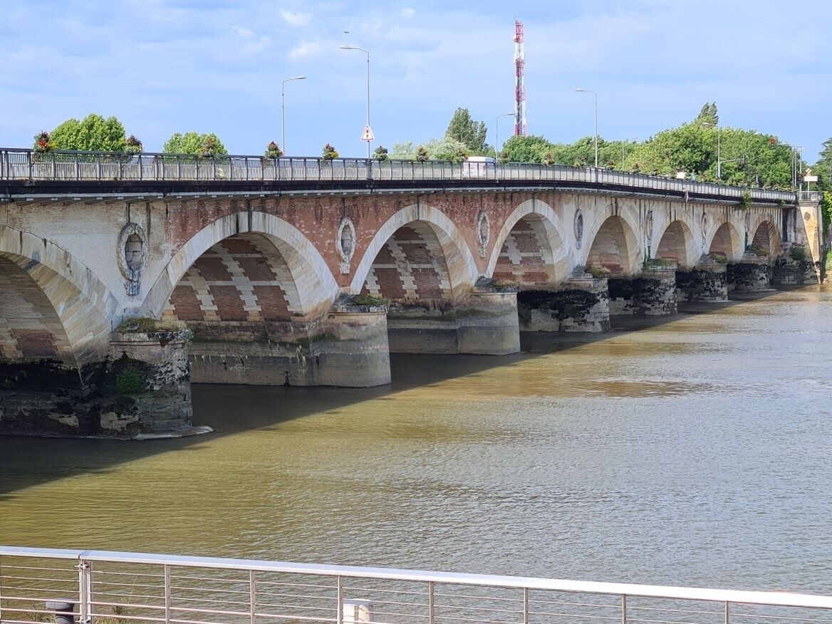 A stone bridge with multiple arches over a river.