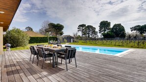 A wooden deck with a pool, outdoor furniture, and a vineyard in the background. - Villa Héloïse - Three Bedroom House, Sleeps 6 (Camblanes-et-Meynac)
