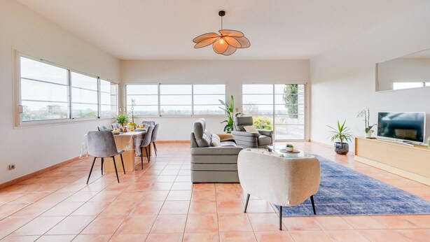 A spacious living area with a dining table, sofa, TV, and large windows. - Villa Héloïse - Three Bedroom House, Sleeps 6 (Camblanes-et-Meynac)