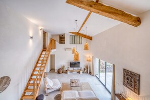 Un interno moderno con una scala, un divano, un tavolino da caffè e una televisione.