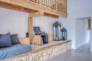 Een moderne woonkamer met een houten bank, een sofa en een platenspeler.