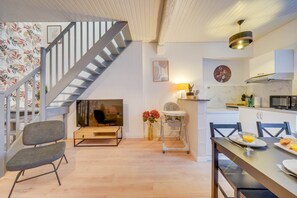 Une cuisine moderne avec une table Ă manger, des chaises et un escalier menant Ă un autre niveau.