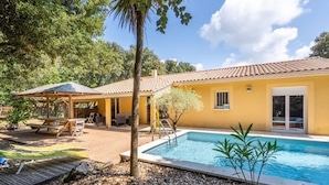 A yellow building with a swimming pool, a covered patio, and a small garden area. - Rosie - Jolie maison avec terrasse et piscine (Le Verdon-sur-Mer)
