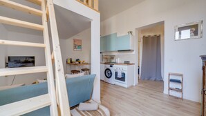Habitació amb lliteres, rentadora i petita cuina.