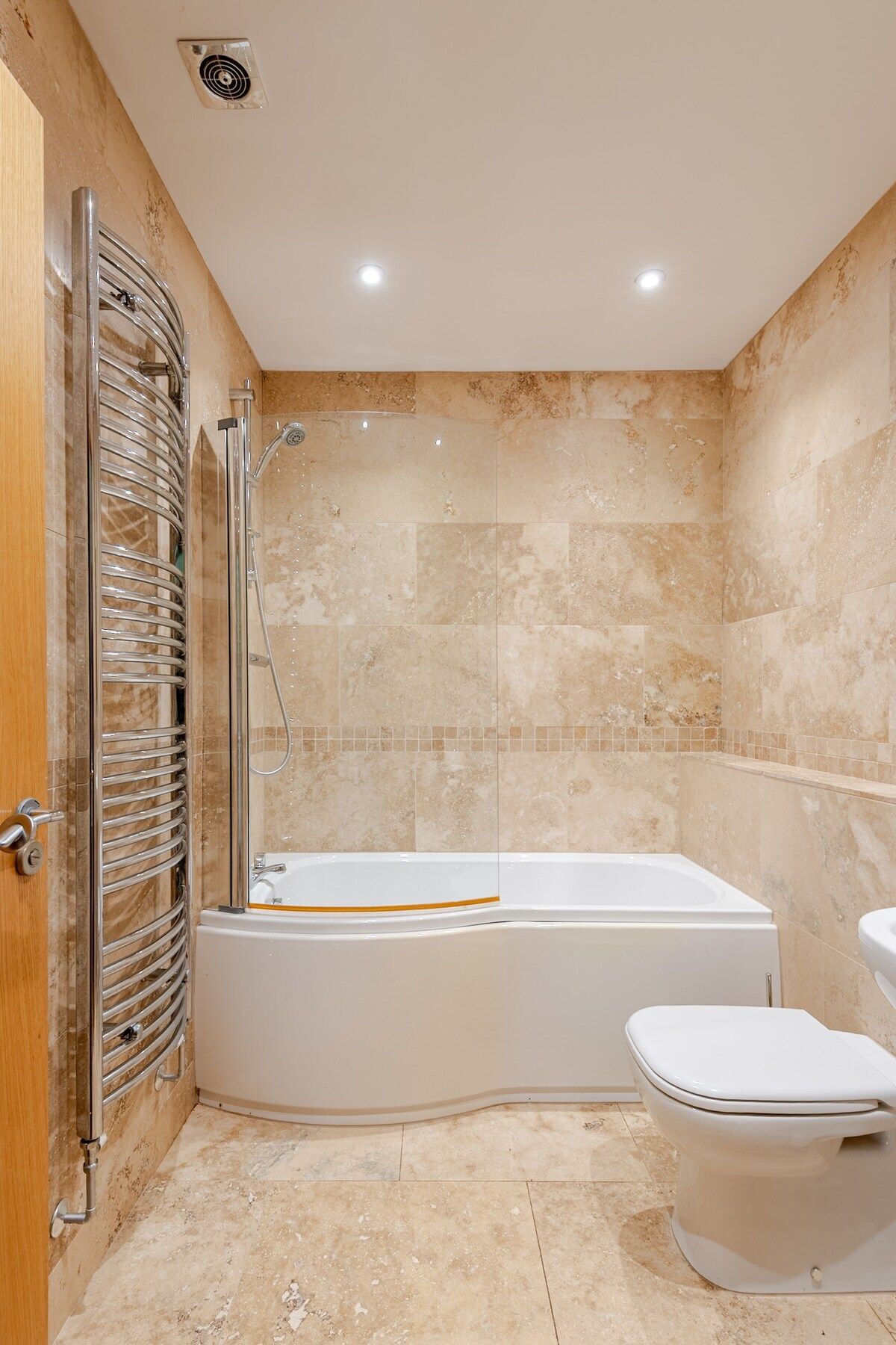 Un baño con bañera, inodoro y zona de ducha.