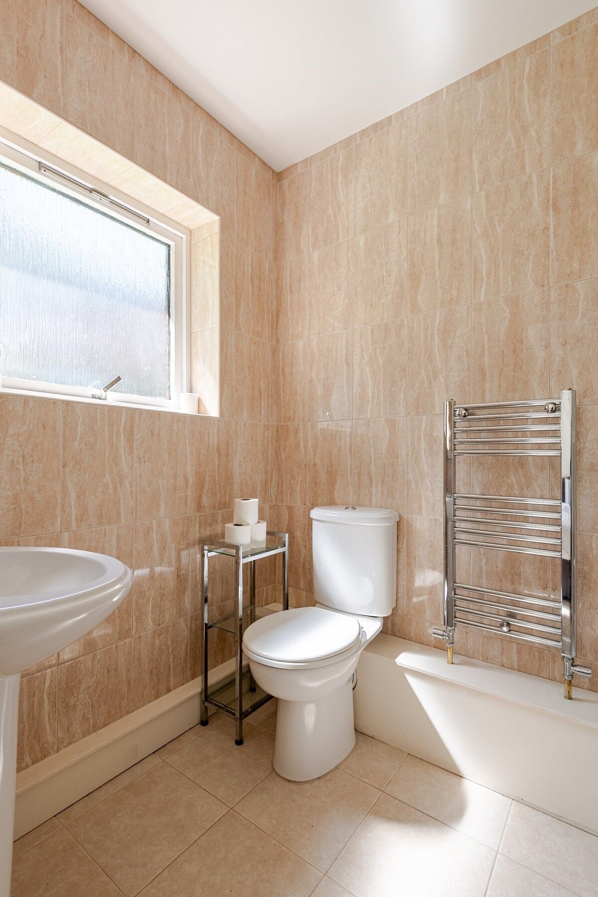 Une salle de bain équipée de toilettes, d’un lavabo et d’un porte-serviettes.