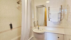 A bathroom with a bathtub, a sink, a toilet, and a shower curtain. - Monifieth Farm Hotel (Dundee)