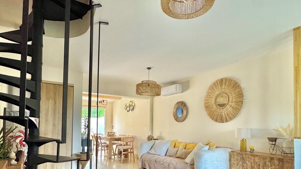 A modern living room with a spiral staircase, a dining area, and a sofa set. - House near downtown Saint-Tropez (Gassin)