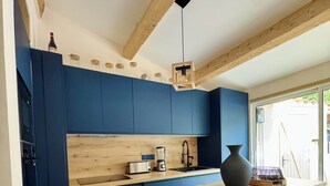 A modern kitchen with blue cabinets, a wooden island, a toaster, and a sink. - House near downtown Saint-Tropez (Gassin)