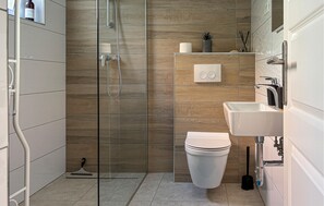 Ein modernes Badezimmer mit Duschkabine, Toilette und Waschbecken.