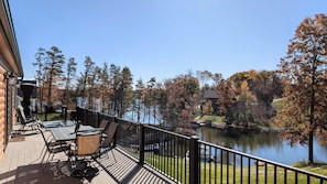 A wooden deck with outdoor furniture, a view of a lake, and surrounding trees. - Peaceful Lakefront Cabin w/ Private Dock and Kayaks (Athens)
