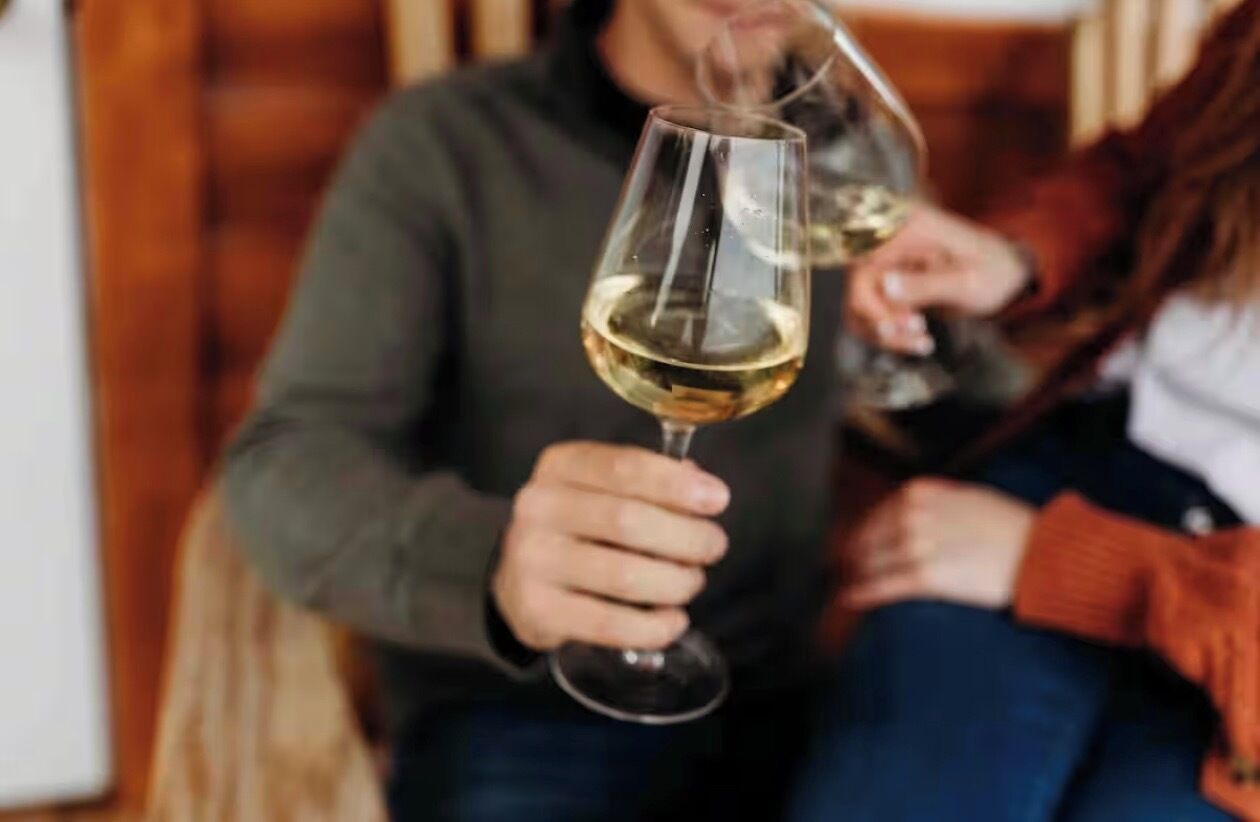 A person holding a wine glass.
