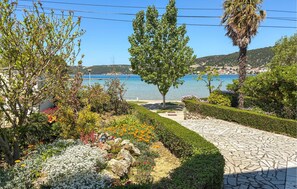 En anlagt have med en stentrappe, forskellige planter og havudsigt.