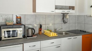 A kitchen with a microwave, toaster, kettle, sink, and cabinets. - 1 bedroom cozy apartment in Rab Sup.Draga (Rab Sup.Draga)